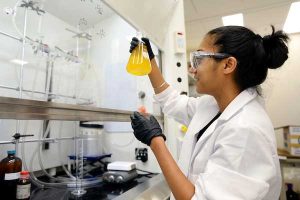 Graduate student working in lab in Marsico Hall
